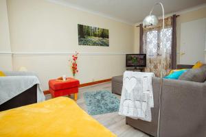 a living room with a couch and a table at Oakley View in Corby