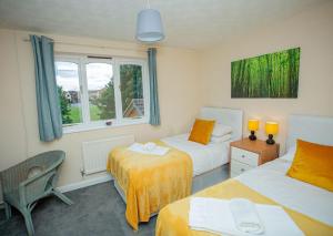 a bedroom with two beds and a window at Oakley View in Corby