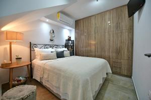 1 dormitorio con 1 cama y pared de madera en Agate Hydra luxury apartment, en Hydra