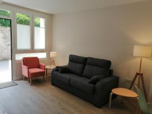 una sala de estar con un sofá y una silla en Apartamento La Cuculla, en Ezcaray