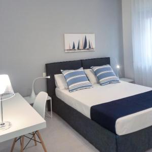 a bedroom with a bed with blue and white pillows at Athena Design Apartment in Siracusa