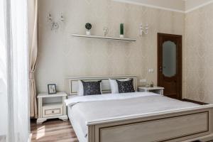een slaapkamer met een wit bed en een spiegel bij InshiApartments on Valova str in Lviv
