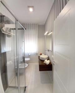 a bathroom with a shower and a sink and a toilet at Athena Design Apartment in Siracusa