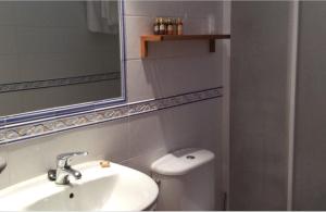 a bathroom with a sink and a toilet and a mirror at Hotel Rural Los Roturos in Maestu