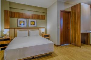 um quarto com uma cama grande e uma porta de madeira em Klein Ville São Leopoldo em São Leopoldo