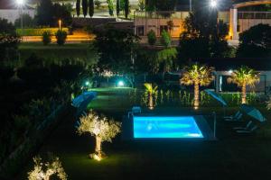 a swimming pool with lights in a yard at night at Ribeira House in Mirandela