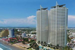 two tall buildings on the beach next to the ocean at Camino al Mar exclusivo Departamento acceso directo playa in Mazatlán
