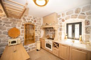 een keuken met stenen muren en een aanrecht met een magnetron bij SEASIDE HOUSE KOTOR in Kotor