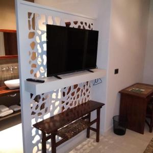 Una sala de estar con un televisor de pantalla plana en una pared. en Mestizo Hotel, en Lincoln