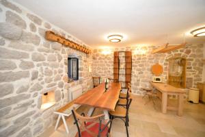 een eetkamer met een stenen muur en een houten tafel bij SEASIDE HOUSE KOTOR in Kotor