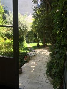eine offene Tür zu einer Terrasse mit einem Tisch und Stühlen in der Unterkunft Hotel Val De Loire in Tours