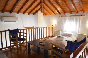 a bedroom with a bed and a table and chairs at Kalokairi Cottage in Skopelos Town