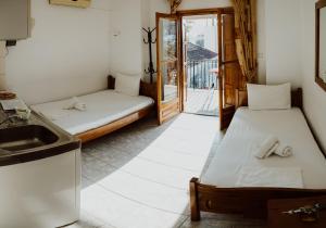 una cocina con 2 camas en una habitación con lavabo en Filippos Rooms Afissos, en Áfissos