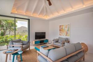 a living room with a couch and a tv at Villa King Gustaf in Gustavia