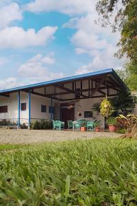 a white building with a blue roof and some grass at Balsora Hotel Boutique in La Tebaida