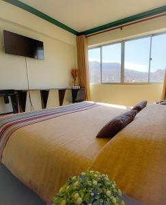 a bedroom with a large bed with a large window at Hotel Sagarnaga in La Paz