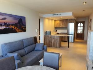 sala de estar con sofá y cocina en Apartamentos Colón - Grupo Antonio Perles en Calpe