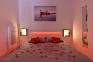una camera da letto con un letto con rose rosse sopra di Love Room - Suite romantique avec spa privatif a Le Puy en Velay