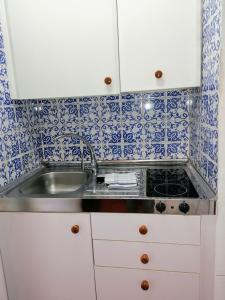 a small kitchen with a sink and blue and white tiles at Aldea 2 Cala Fornells in Paguera