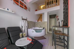 un soggiorno con un divano e una vasca da bagno di Love Room - Suite romantique avec spa privatif a Le Puy en Velay Altre 40 foto
