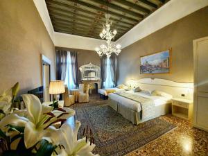 a bedroom with two beds and a chandelier at Hotel Corte dei Greci in Venice