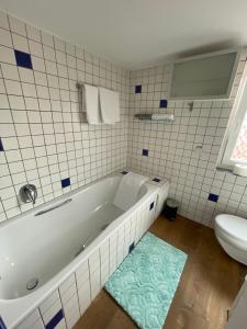 een witte badkamer met een bad en een toilet bij Ferienwohnung Bartenwetzerbrücke 2 in Melsungen