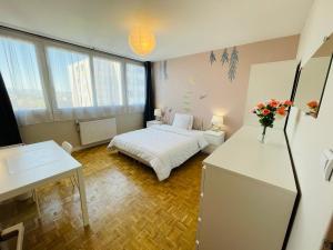 um pequeno quarto com uma cama e uma secretária com flores em Chambre Privée en Colocation Villeurbanne Métro Bonnevay em Villeurbanne