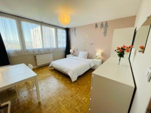 Habitación pequeña con cama y escritorio con flores en Chambres privées en colocations Lyon Villeurbanne Bonnevay, en Villeurbanne