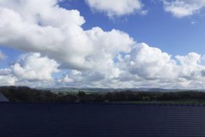 un grand champ avec un ciel aux nuages dans l'établissement The Stable, à Aberystwyth