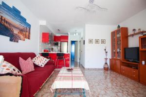 Una sala de estar con un sofá rojo y una cocina. en Pueblo Andaluz 921, en Torrox Costa