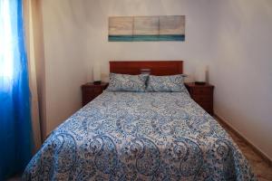 Un dormitorio con una cama con un edredón azul y blanco. en Pueblo Andaluz 921, en Torrox Costa