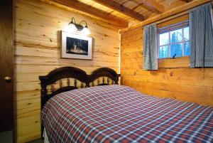 una camera con un letto in una baita di tronchi di Pioneer Guest Cabins a Crested Butte Altre 30 foto
