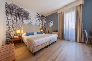 a bedroom with a large bed with blue pillows at Hotel Al Sole Bardolino in Bardolino