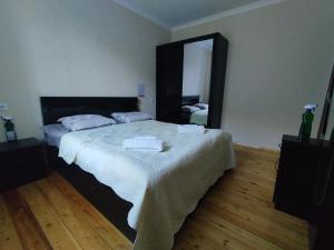 a bedroom with a large bed with two towels on it at Kamara Guest House in Kazbegi