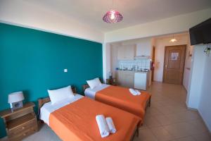 a hotel room with two beds and a kitchen at Elena Studios in Athani