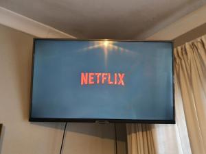 a television with the netflix sign on a wall at Happy colourful cottage in Johannesburg
