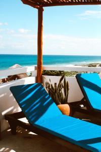 Kay Apartments Isla Mujeres في إيسلا موخيريس: مقعد أزرق على شرفة مع المحيط