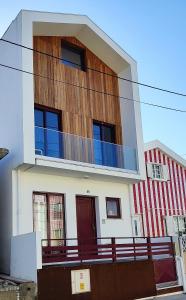 uma casa branca com uma varanda em cima em Casa na Costa em Costa Nova