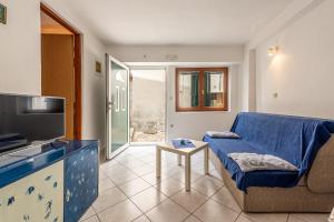 a living room with a couch and a tv at Apartment Bura in Primošten