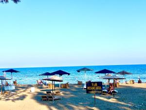 una playa con sombrillas y gente en la playa en Vm Resort Otel Mersin, en Mersin