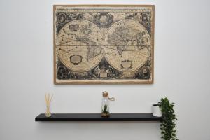 a map of the world on a wall with a shelf at Boothen House by YourStays in Stoke on Trent