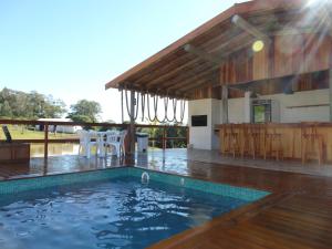 a swimming pool in front of a house at BANGALÔS REFÚGIO DO VALE in Santa Maria do Erval