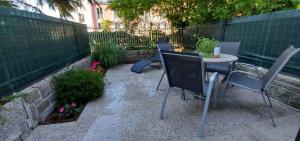 a patio with a table and chairs and a fence at Apartma Žusterna za bazenom in Koper