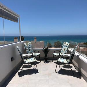 three chairs on a balcony with a view of the ocean at Villa Isla Plana - right by the sea in Isla Plana