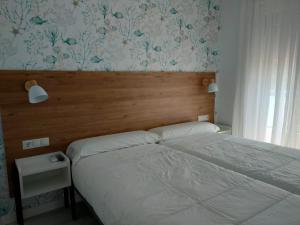 a bedroom with a bed with a wooden head board at Rodeiramar 2A in Cangas de Morrazo