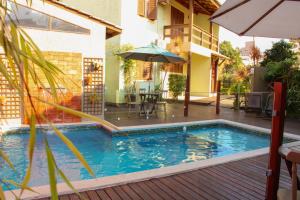a swimming pool with a table and an umbrella at Pousada Do Capitão in Florianópolis