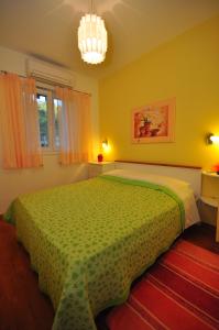 1 dormitorio con 1 cama grande con colcha verde en TRI PALME, en Prvić Šepurine