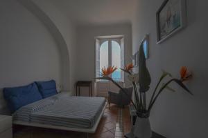 a living room with a bed and a vase with flowers at Casa di charme panoramica a Capri sulla spiaggia. in Capri