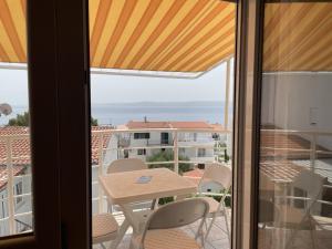 a balcony with a table and chairs and a view of the ocean at Apartments Papic in Trogir
