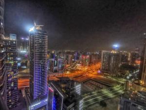 a city skyline at night with a tall building at OSKENA Vacation Homes - Damac Maison Dubai Mall Street in Dubai